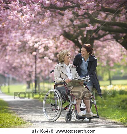 Stock Photo - Older woman with caretaker in park. Fotosearch