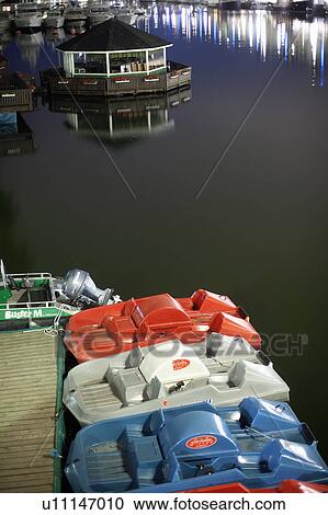 Stock Image - Paddle boats docked in still lake. Fotosearch