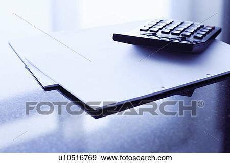 Stock Photo - Papers and calculator on office desk. Fotosearch