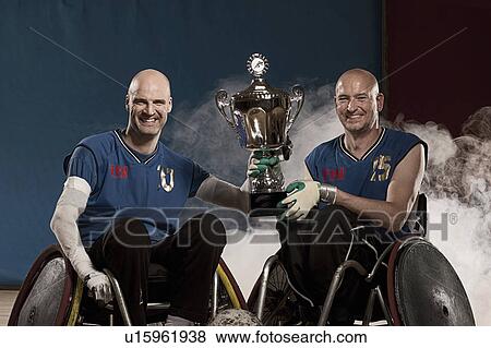 Stock Photo - Para rugby players cheering with trophy. Fotosearch