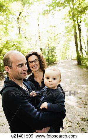 Parents carrying baby in park View Large Photo Image Stock Photo - Parents carrying baby in park. Fotosearch