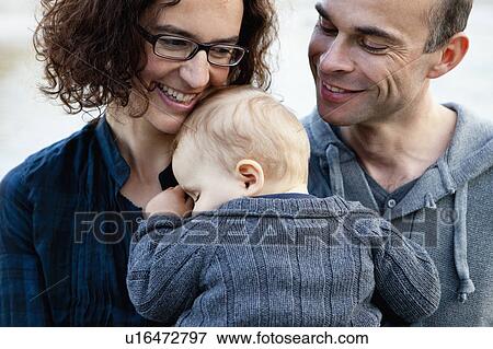 Stock Photo - Parents holding sleeping baby. Fotosearch