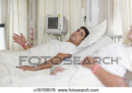 Stock Photograph - Patients talking in hospital beds. Fotosearch