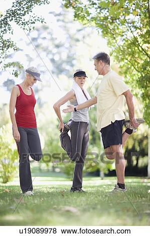 Stock Photo - People stretching together outdoors. Fotosearch