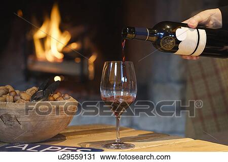 Person pouring wine by fireplace View Large Photo Image Stock Image - Person pouring wine by fireplace. Fotosearch