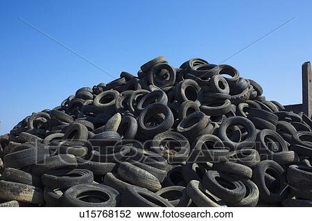 Stock Image - Pile of old tires under blue sky. Fotosearch
