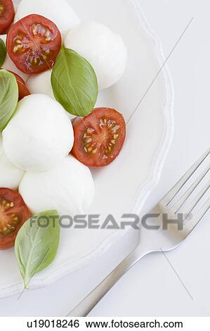 Stock Photograph - Plate of mozzarella, tomatoes and basil. Fotosearch