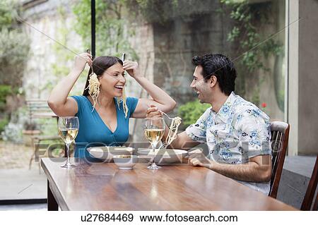 Playful couple eating together at table View Large Photo Image Stock Photo - Playful couple eating together at table. Fotosearch