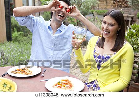 Playful couple eating together outdoors View Large Photo Image Stock Photograph - Playful couple eating together outdoors. Fotosearch