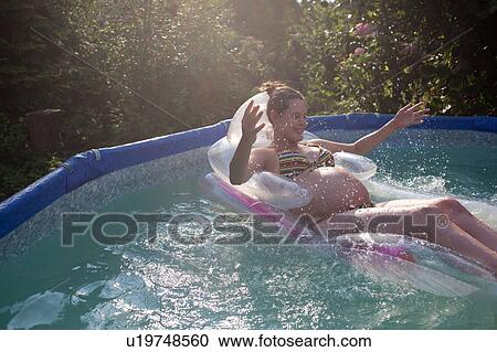 Pregnant woman floating in pool View Large Photo Image Stock Image - Pregnant woman floating in pool. Fotosearch