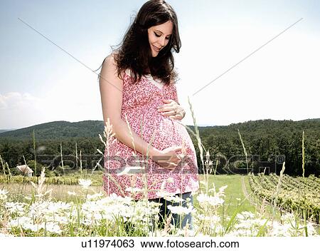 Stock Image - Pregnant woman holding her belly. Fotosearch
