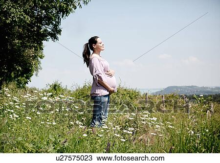 Pregnant woman holding her belly View Large Photo Image Stock Image - Pregnant woman holding her belly. Fotosearch