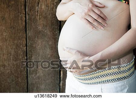Pregnant woman holding her belly View Large Photo Image Stock Photo - Pregnant woman holding her belly. Fotosearch