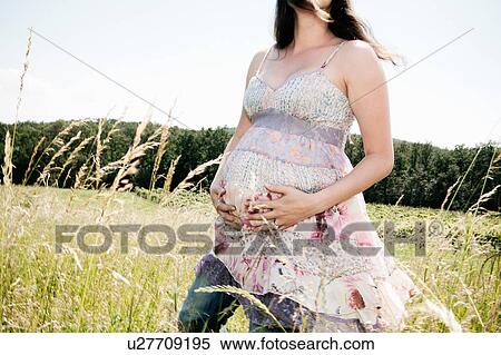Stock Photography - Pregnant woman holding her belly. Fotosearch