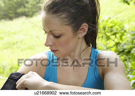 Stock Image - Runner adjusting armband. Fotosearch
