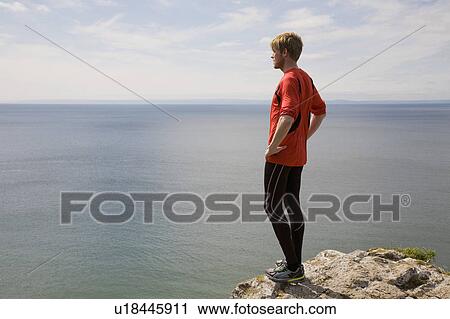 Stock Image - Runner admiring coastal landscape. Fotosearch