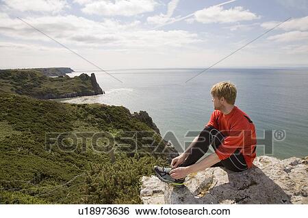 Stock Photograph - Runner admiring coastal landscape. Fotosearch