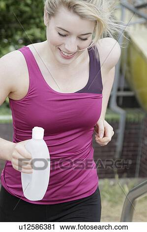 Stock Image - Runner carrying circular water bottle. Fotosearch