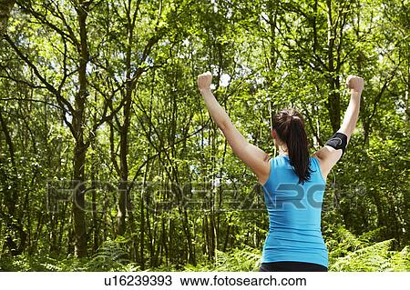 Stock Image - Runner cheering in forest. Fotosearch