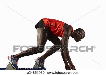 Runner crouched at starting line View Large Photo Image Stock Image - Runner crouched at starting line. Fotosearch