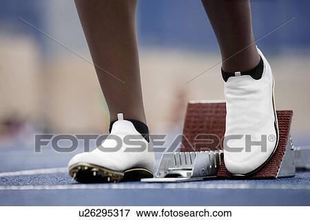 Stock Photo - Runner poised at starting block. Fotosearch