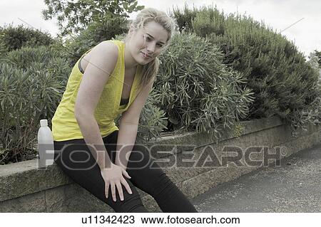 Runner resting on brick wall in park View Large Photo Image Stock Image - Runner resting on brick wall in park. Fotosearch