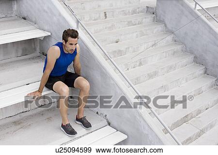 Runner resting on stadium steps View Large Photo Image Stock Photo - Runner resting on stadium steps. Fotosearch