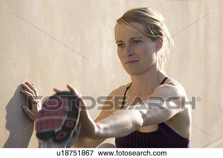 Runner stretching against wall View Large Photo Image Stock Photo - Runner stretching against wall. Fotosearch