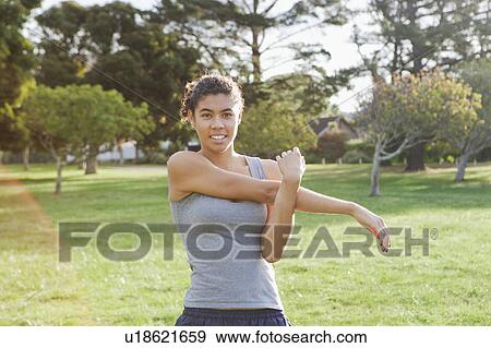 Runner stretching in field View Large Photo Image Stock Photo - Runner stretching in field. Fotosearch