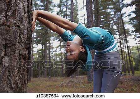 Picture - Runner stretching in forest. Fotosearch