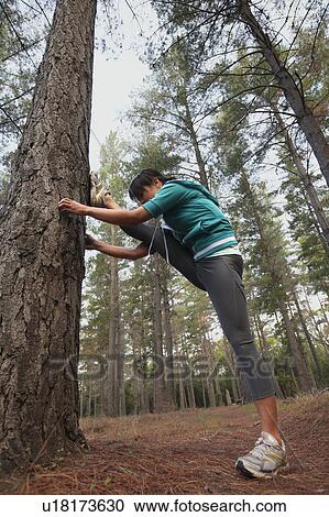 Stock Image - Runner stretching in forest. Fotosearch
