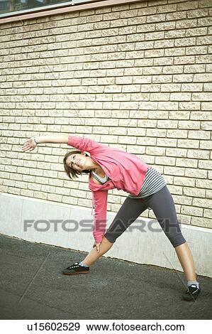 Stock Photo - Runner stretching on city street. Fotosearch