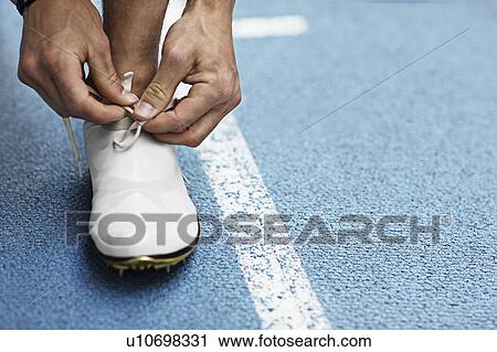 Runner tying shoelaces View Large Photo Image Stock Image - Runner tying shoelaces. Fotosearch