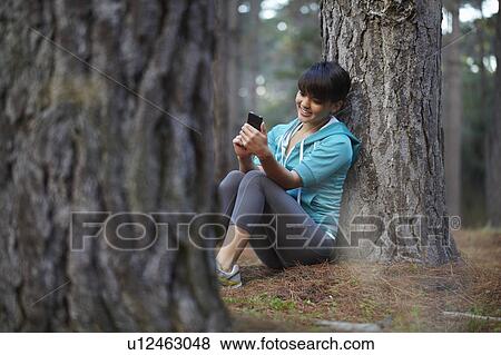 Runner using cell phone in forest View Large Photo Image Stock Photo - Runner using cell phone in forest. Fotosearch