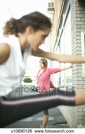 Stock Photograph - Runners stretching against wall. Fotosearch