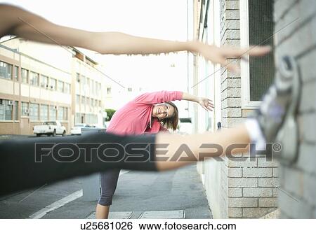 Runners stretching against wall View Large Photo Image Stock Photograph - Runners stretching against wall. Fotosearch