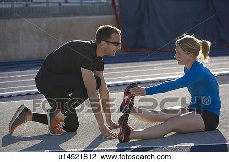 Stock Image - Runners stretching together on track. Fotosearch