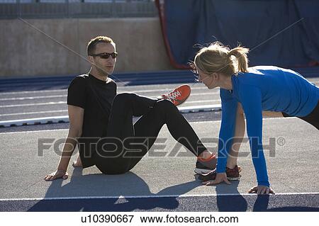 Stock Photo - Runners stretching together on track. Fotosearch
