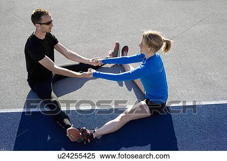 Runners stretching together on track View Large Photo Image Stock Photography - Runners stretching together on track. Fotosearch