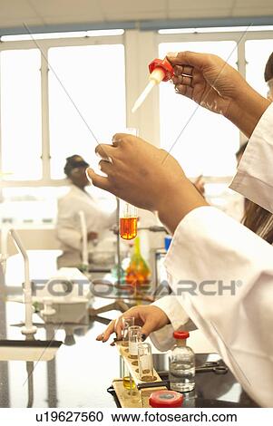 Scientist adding solution to test tube View Large Photo Image Stock Image - Scientist adding solution to test tube. Fotosearch