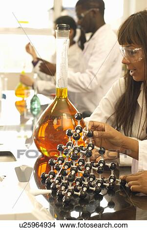Scientist examining beaker in lab View Large Photo Image Picture - Scientist examining beaker in lab. Fotosearch
