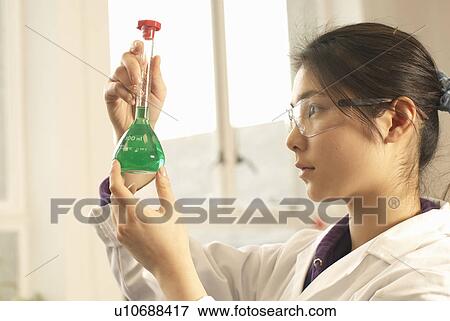 Scientist examining liquid in beaker View Large Photo Image Stock Photo - Scientist examining liquid in beaker. Fotosearch
