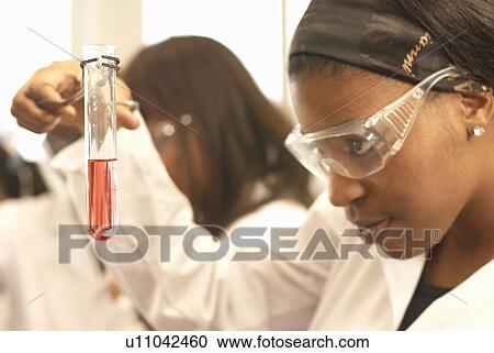 Stock Image - Scientist examining liquid in test tube. Fotosearch