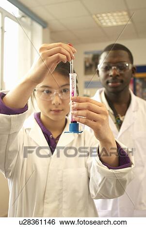 Stock Photograph - Scientist examining liquid in test tube. Fotosearch