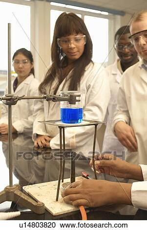 Scientist heating liquid in beaker View Large Photo Image Stock Image - Scientist heating liquid in beaker. Fotosearch