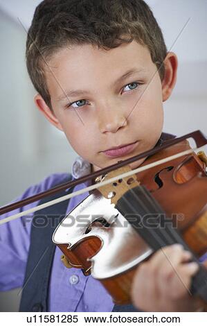 Stock Photography - Serious boy playing violin. Fotosearch