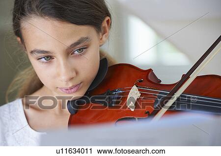 Stock Image - Serious girl playing violin. Fotosearch