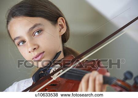 Stock Photo - Serious girl playing violin. Fotosearch