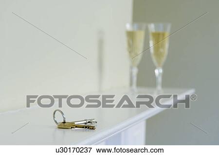 Stock Photo - Set of keys and champagne on mantle. Fotosearch
