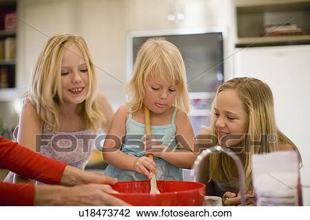 Sisters cooking together in kitchen View Large Photo Image Stock Image - Sisters cooking together in kitchen. Fotosearch